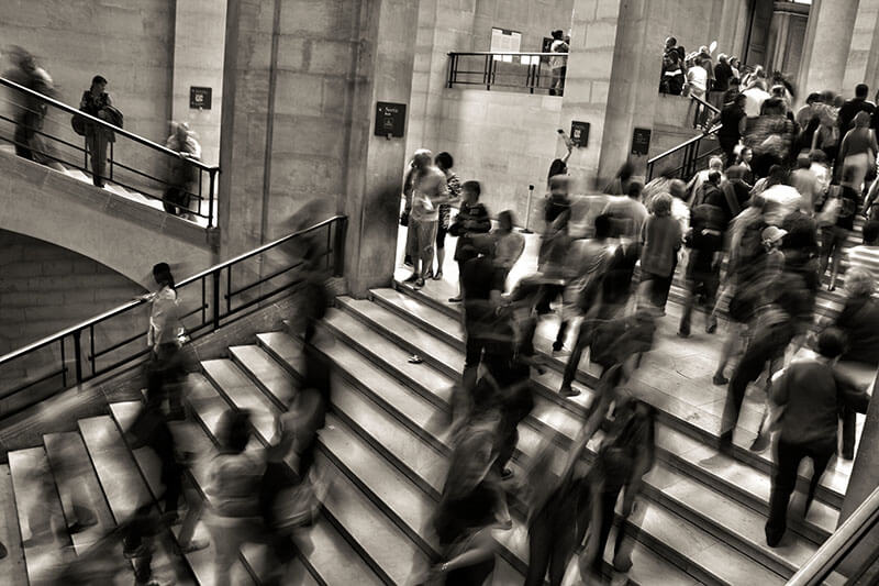 Blurred picture of a large crowd of people walking up and down stairs.