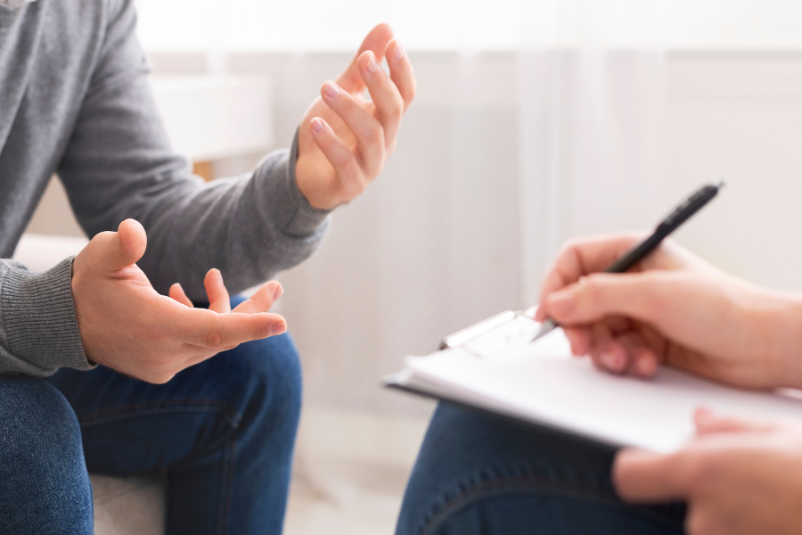 Person using hand gestures and another person writing.