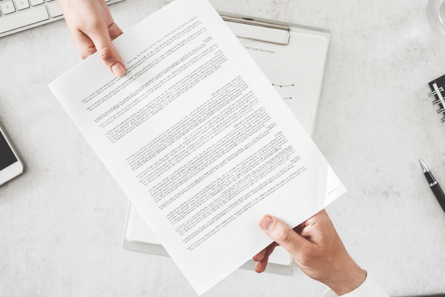 Person handing another person a document.