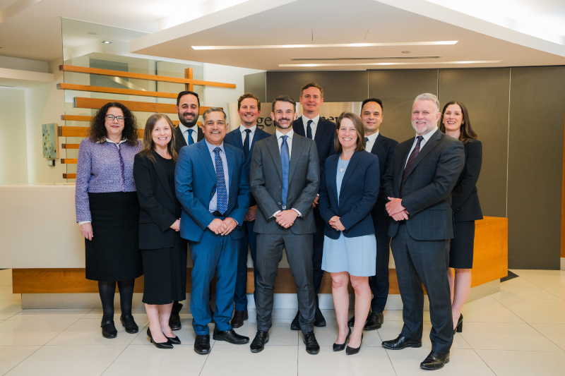 A group of people standing in a reception area smiling for a photo.